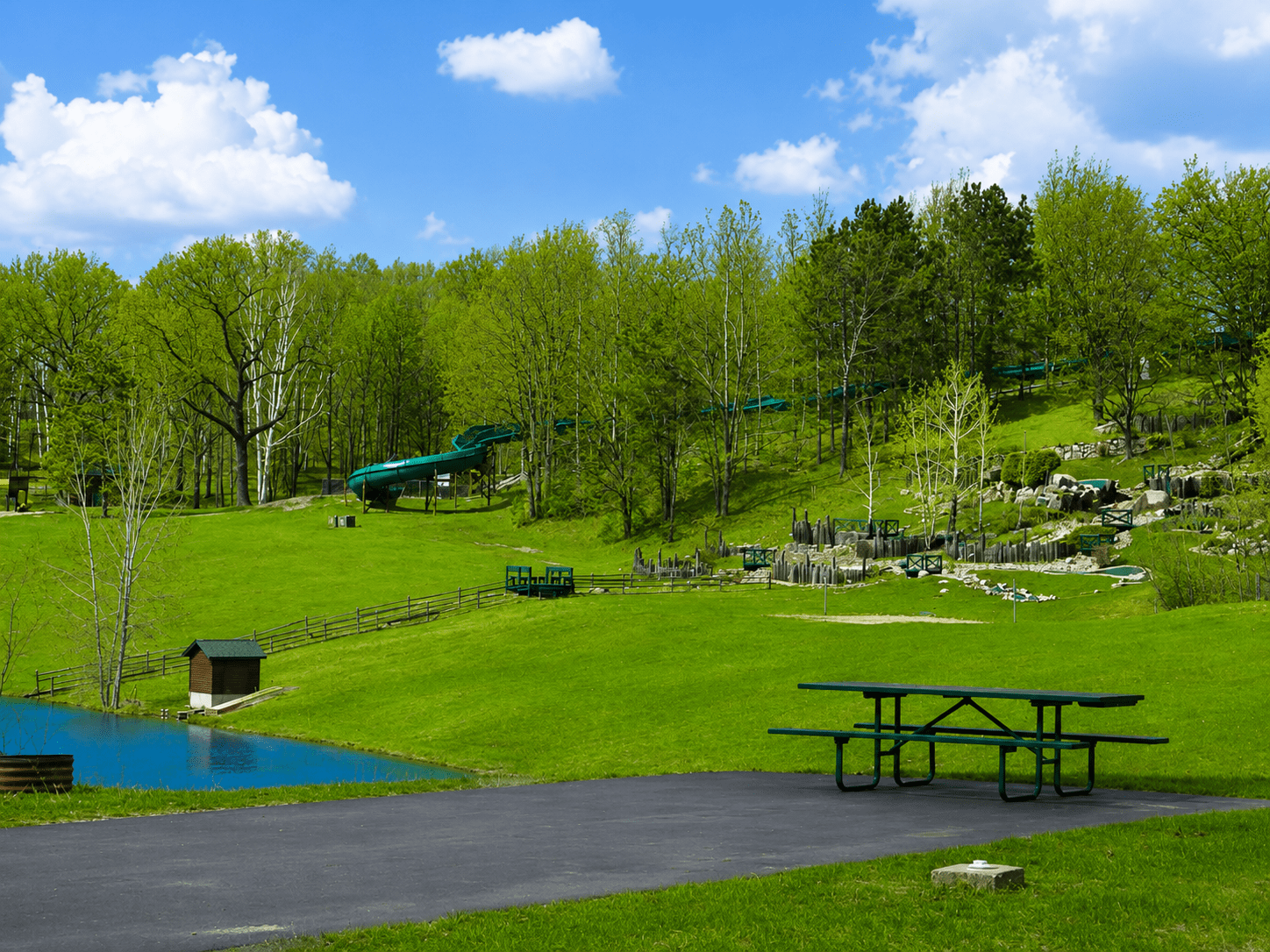 Picnic table overlooking hillside park with waterslide