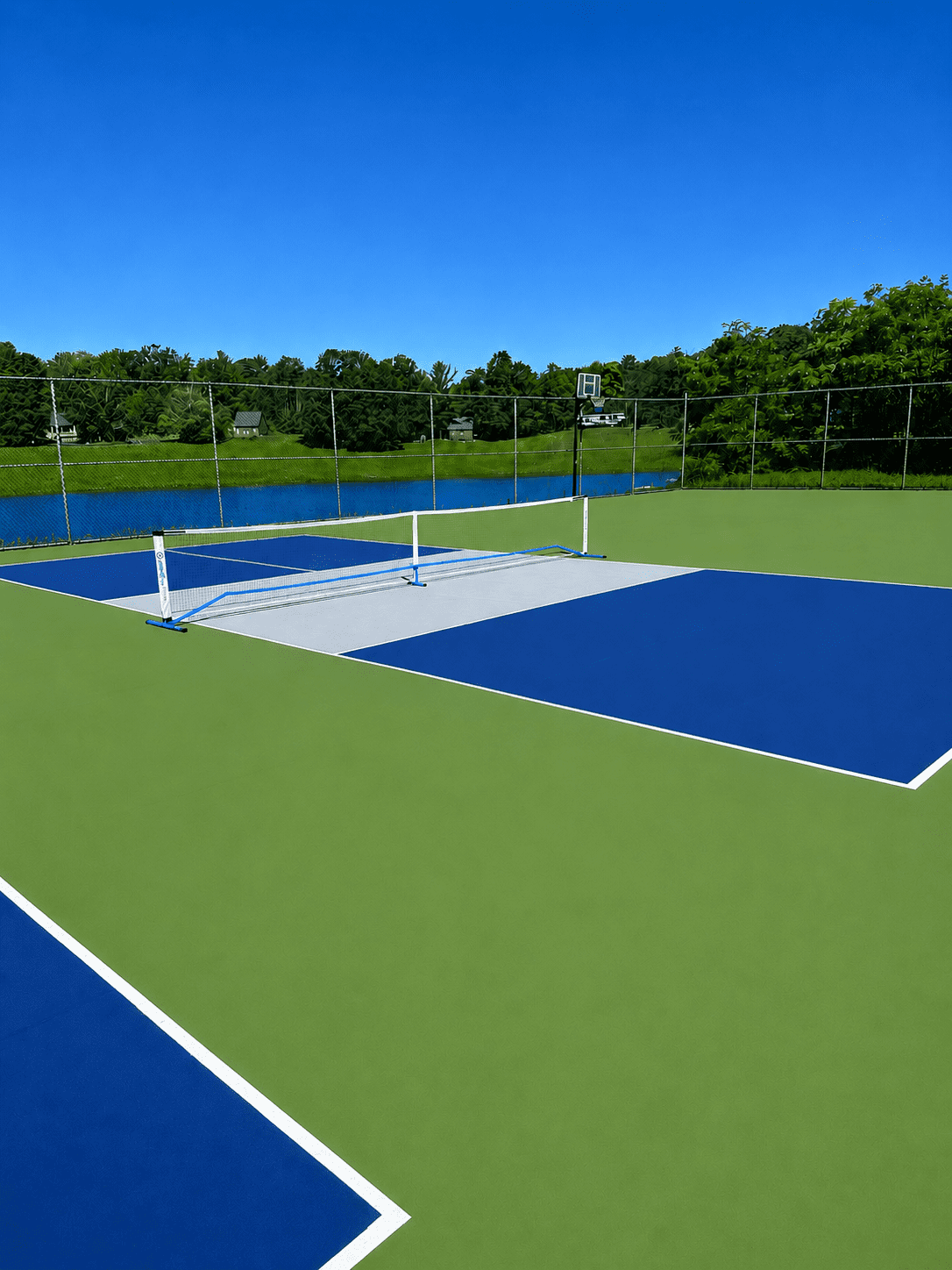 Blue-green pickleball court beside a lake
