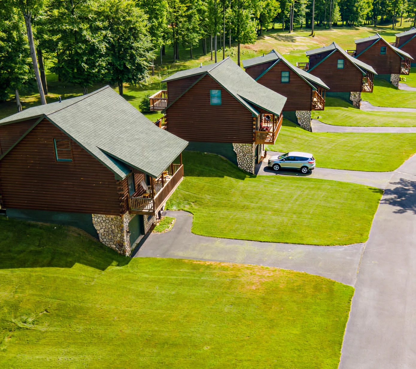 Row of wooden cabins in lush greenery.
