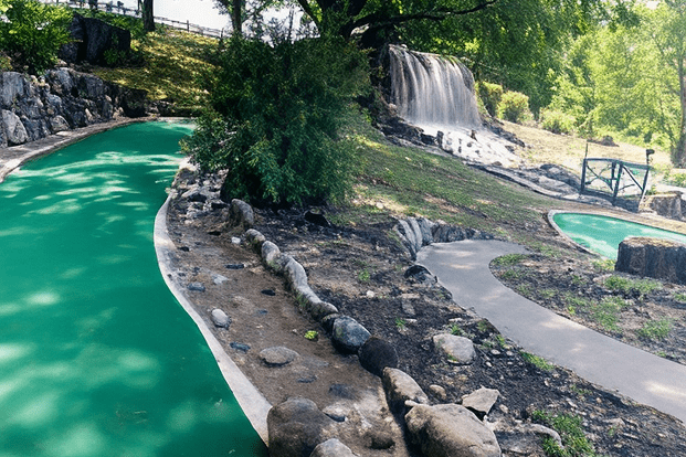 Mini golf course with waterfall and trees.